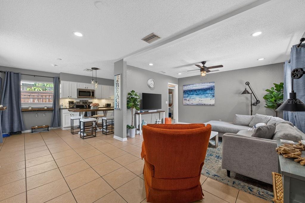 An open-concept living room and kitchen area with tile flooring and gray walls — 610 1ST AVENUE NE, LARGO, FL