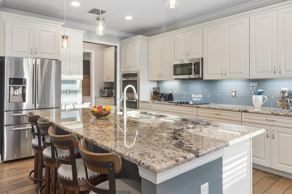 A bedroom features a large wooden bed, gray carpet, and a dark accent wall — 19129 LONG LAKE RANCH BOULEVARD, LUTZ, FL