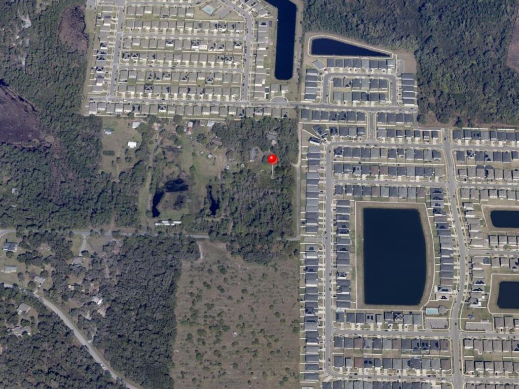 This aerial map shows a wooded lot marked with a red pin near residential neighborhoods — 5455 N EAGLE ROAD, ST CLOUD, FL