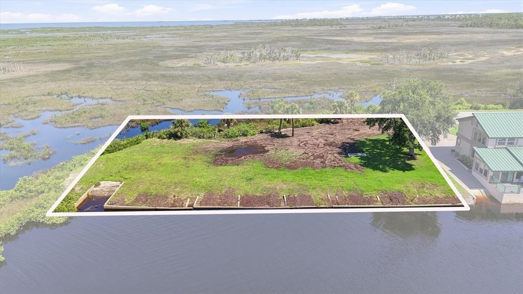 An aerial view shows a waterfront lot with a bulkhead and surrounding marshland — 3190 INDIAN GULF LANE, HERNANDO BEACH, FL