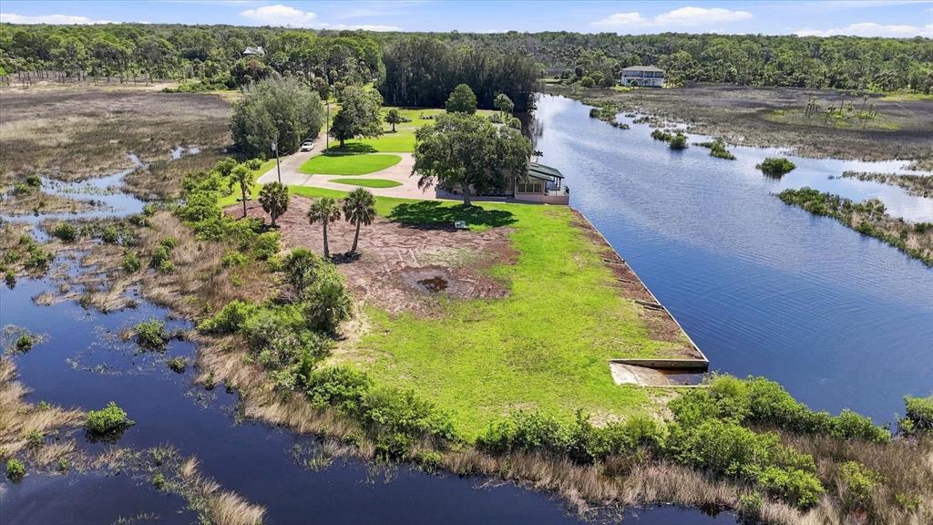 An aerial view shows a waterfront property with a house, lawn, and boat ramp — 3190 INDIAN GULF LANE, HERNANDO BEACH, FL