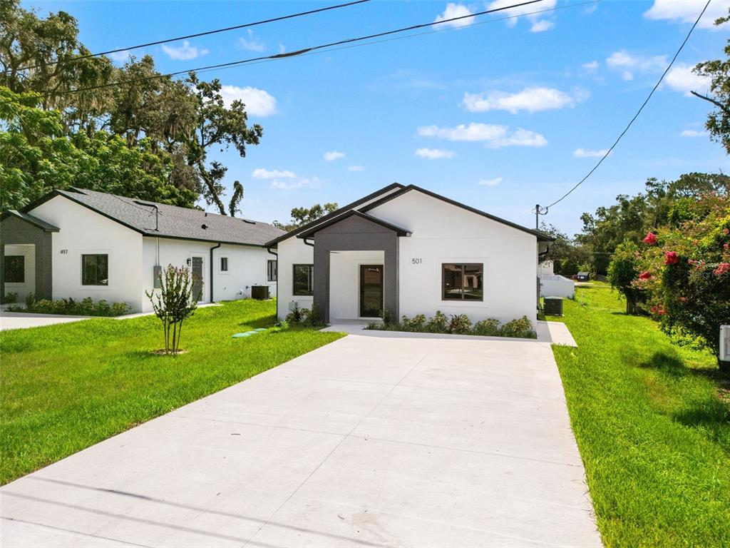A white single-story house with a dark gray entryway and a concrete driveway — 501 OCEAN AVENUE, APOPKA, FL