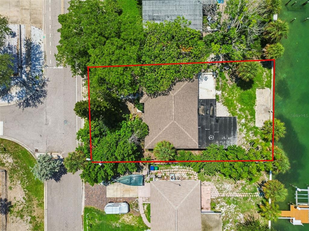 An aerial view shows a house with a brown roof and a flat black roof section — 9300 GULF BOULEVARD, ST PETE BEACH, FL