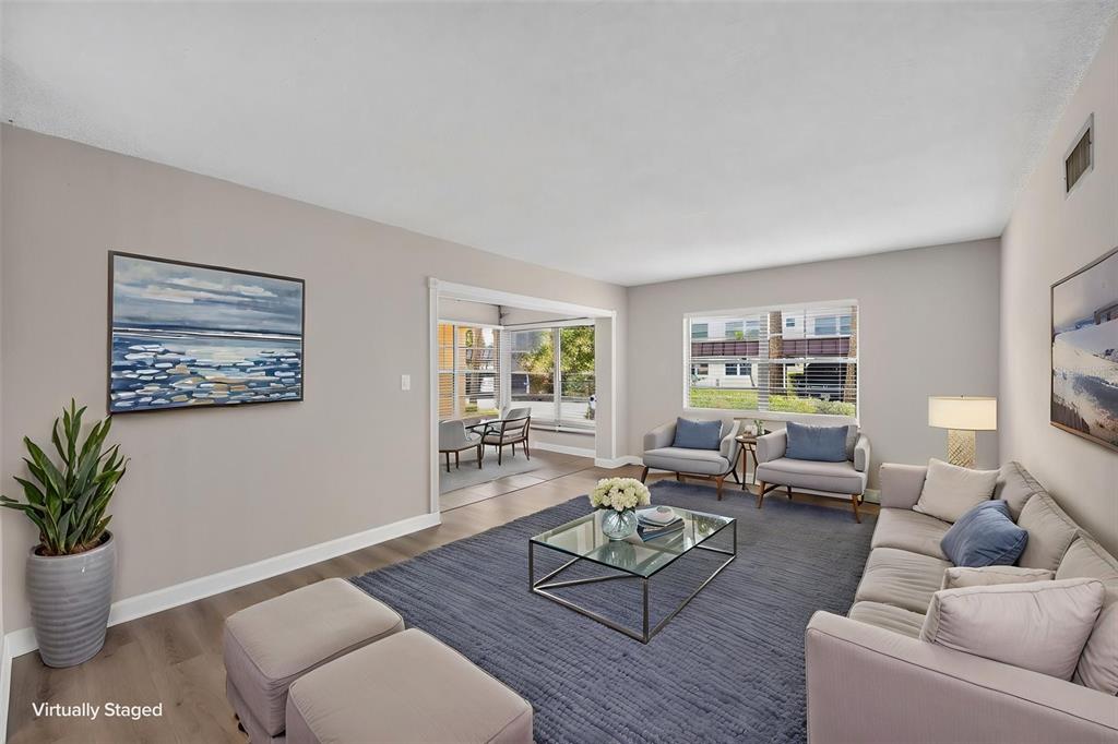 The exterior of a multi-story apartment building features a covered entrance and palm trees — 4780 COVE CIRCLE STREET UNIT 103, ST PETERSBURG, FL