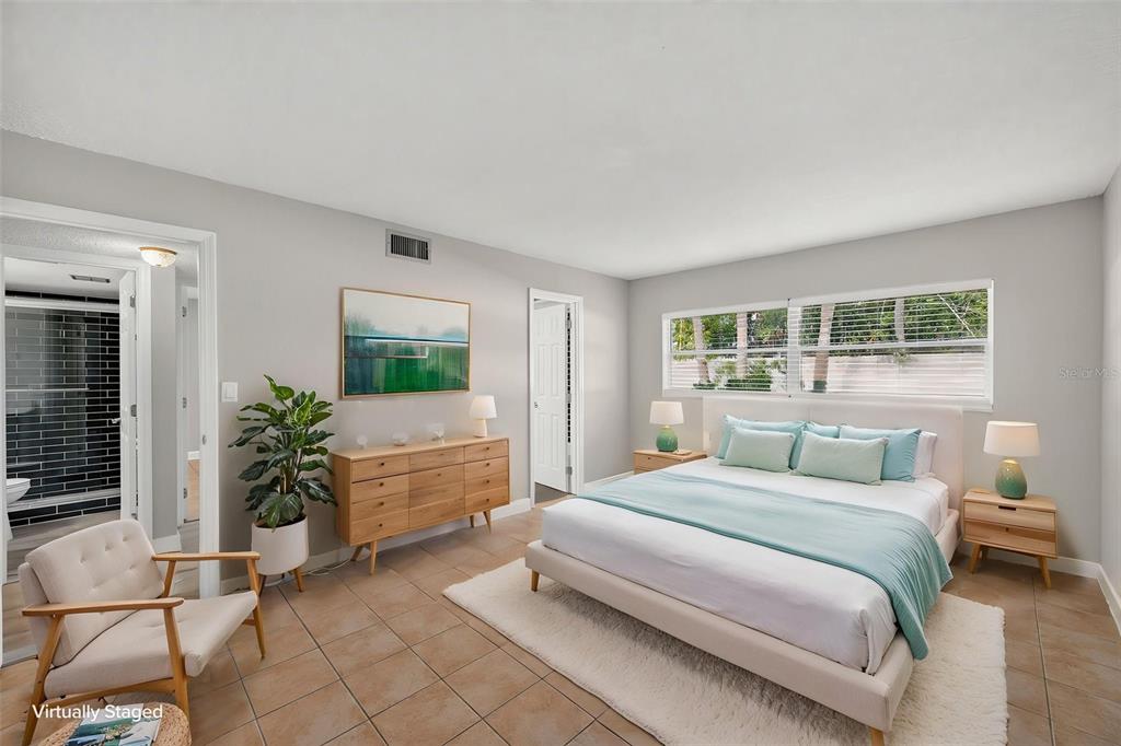 An exterior view of a three-story apartment building with palm trees and a parking lot — 4780 COVE CIRCLE STREET UNIT 103, ST PETERSBURG, FL