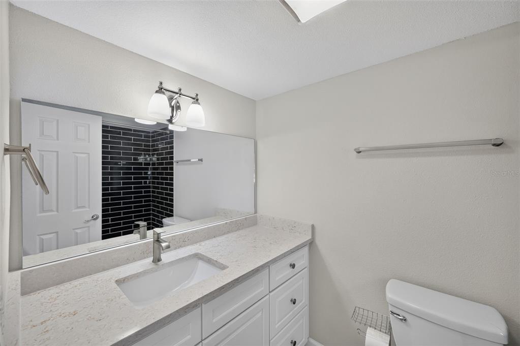 A three-story apartment building with beige stucco walls sits next to a parking lot — 4780 COVE CIRCLE STREET UNIT 103, ST PETERSBURG, FL