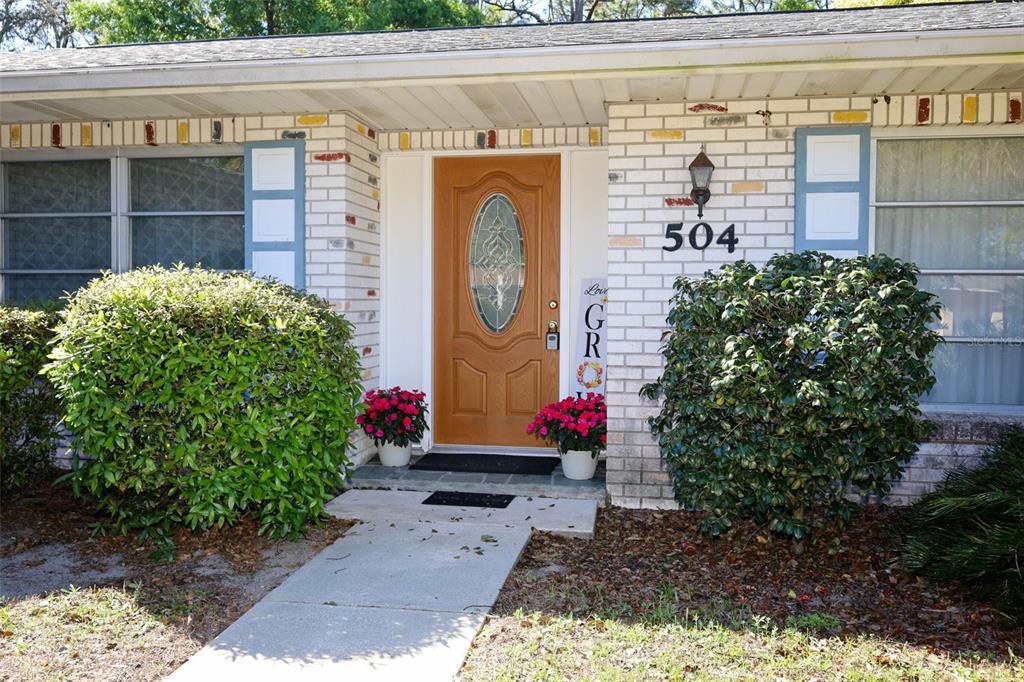 A front entryway features a wood-toned door with a glass oval insert and laminate flooring — 504 RIDGEWOOD STREET, ALTAMONTE SPRINGS, FL