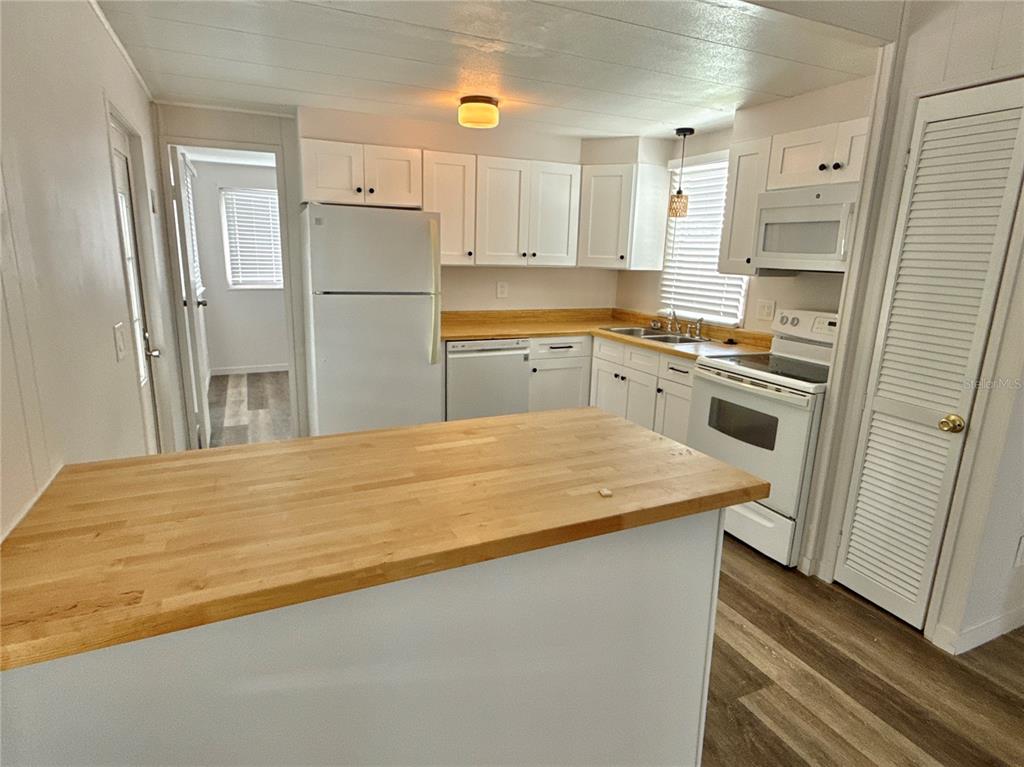 A kitchen features white cabinets, a light wood countertop, and white appliances — 347 MOUNT SAXON AVENUE NE UNIT 324, ST PETERSBURG, FL