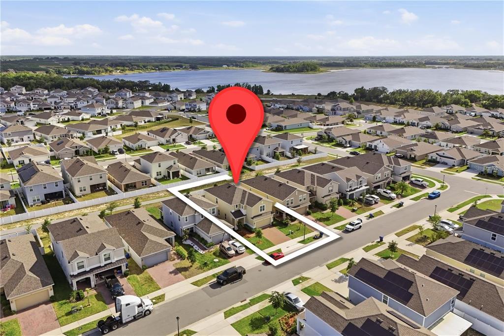 An aerial view shows a suburban neighborhood with a highlighted house and a large lake — 6825 WILSON HAMMOCK AVENUE, GROVELAND, FL