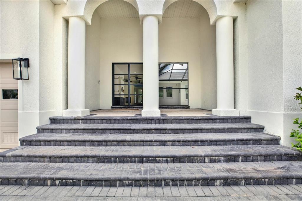 A set of dark stone steps leads up to a covered entryway with three white columns — 1424 JUMANA LOOP, APOLLO BEACH, FL
