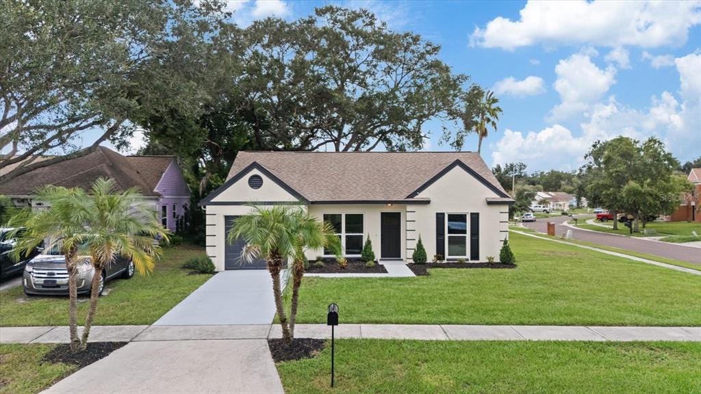 A single-story house with a beige stucco exterior, dark shutters, and a front-facing garage — 1634 CROSSRIDGE DRIVE, BRANDON, FL