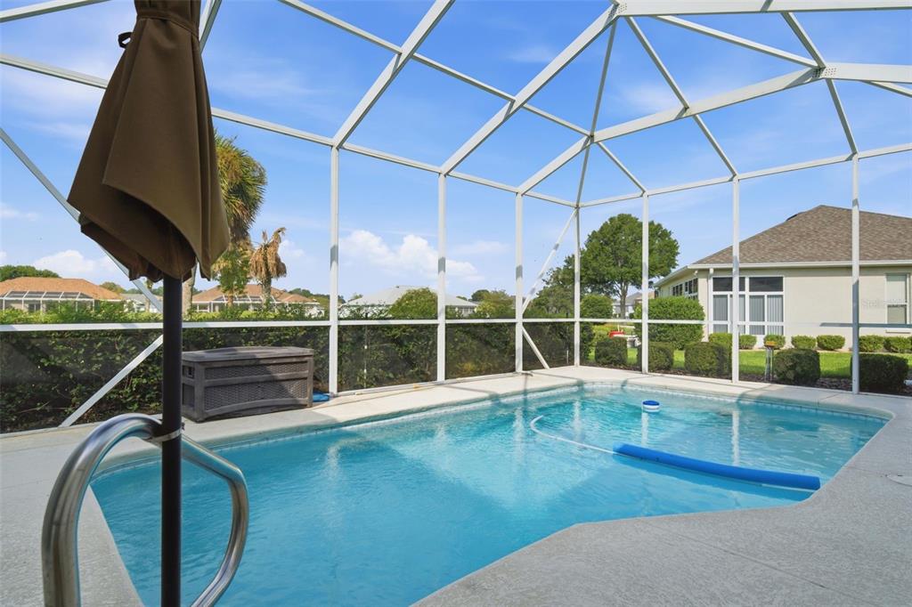 A screened-in swimming pool with a patio and surrounding residential neighborhood views — 2160 NW 50TH CIRCLE, OCALA, FL