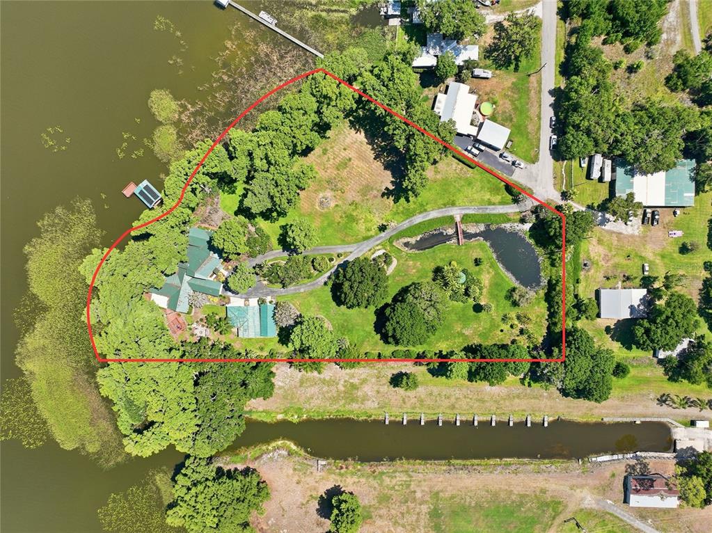 An aerial view shows a large waterfront property with a house, pond, and driveway — 200 WINDY POINT ROAD, LAKE PLACID, FL