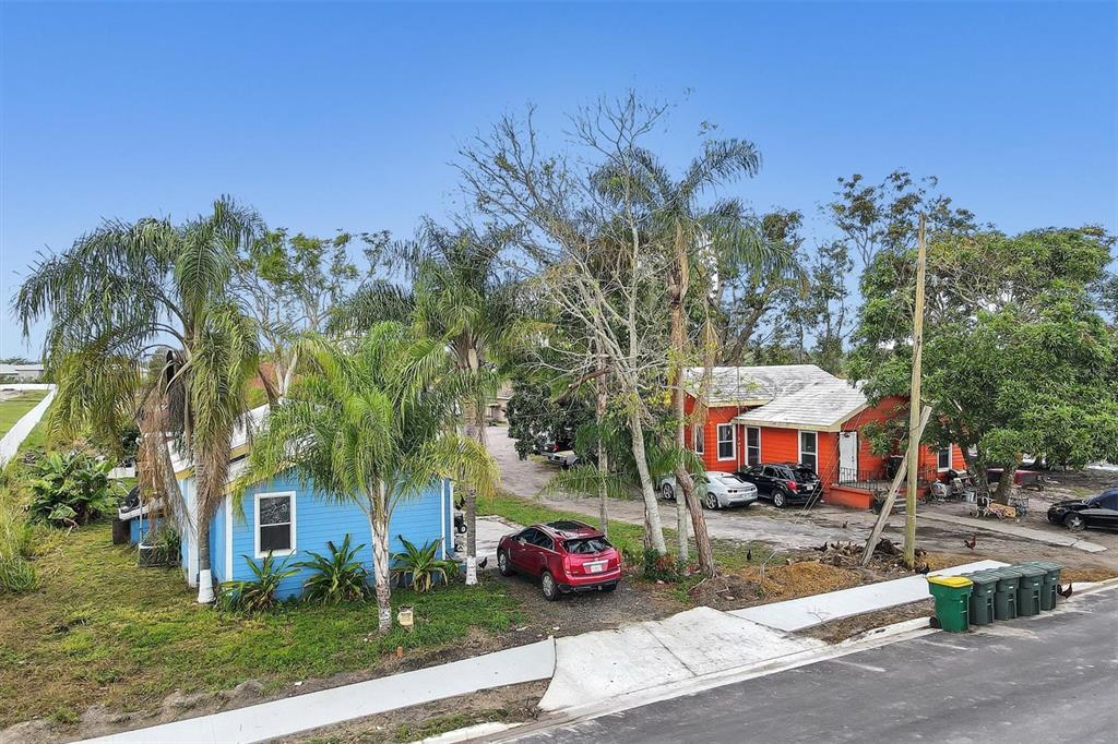 A blue house and an orange house sit on a lot with several palm trees — 1616 23RD STREET E, BRADENTON, FL
