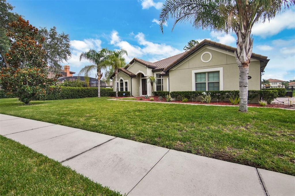 A single-story house with a tan stucco exterior, tile roof, and a front lawn — 119 ROSA BELLA VIEW, DEBARY, FL