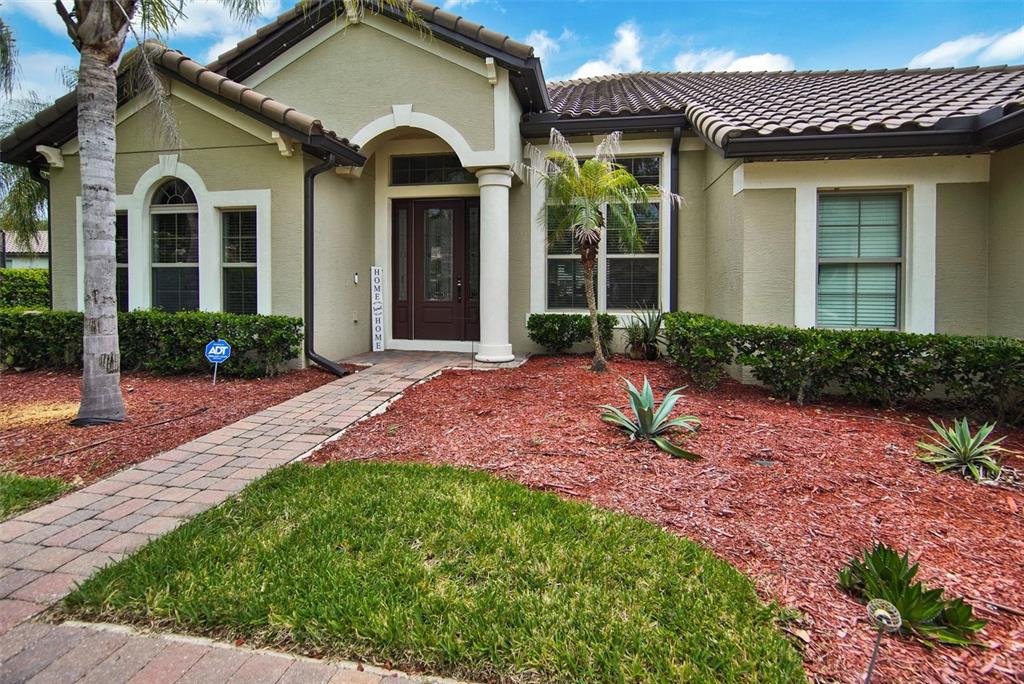 A single-story house with a tiled roof, brick walkway, and red mulch landscaping — 119 ROSA BELLA VIEW, DEBARY, FL