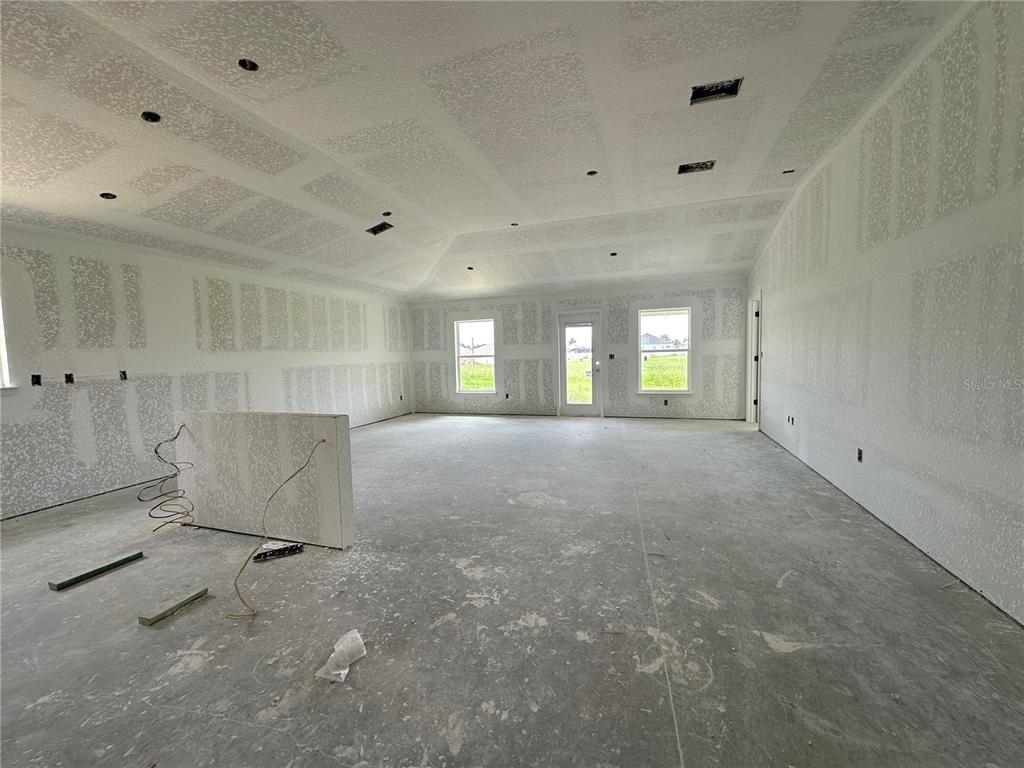 An unfinished room with drywall, a kitchen island base, and a view of a field — 12535 NE 48TH TERRACE, OXFORD, FL