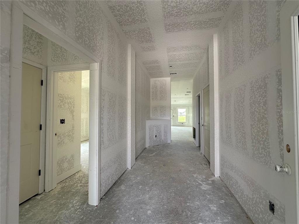 An unfinished hallway with drywall, textured ceilings, and interior doors under construction — 12535 NE 48TH TERRACE, OXFORD, FL