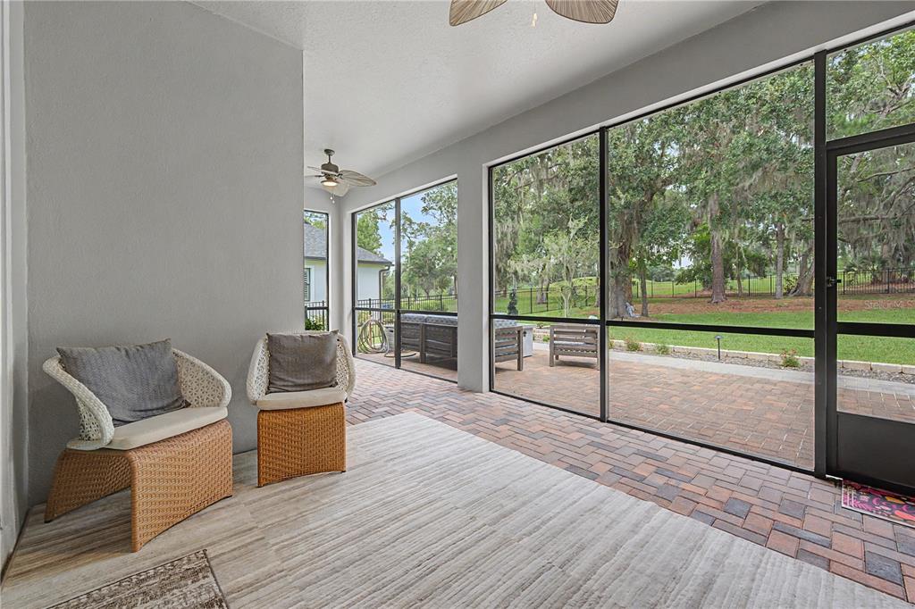A kitchen features dark wood cabinets, granite countertops, a central island, and white bar stools — 4926 SOUTHERN VALLEY LOOP, BROOKSVILLE, FL