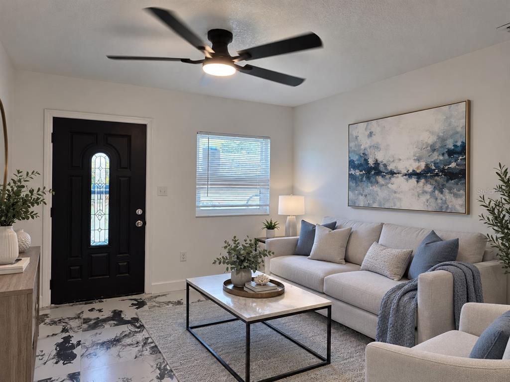 A living room features a black front door, a beige sofa, and a ceiling fan — 606 EL VEDADO AVENUE, ORLANDO, FL