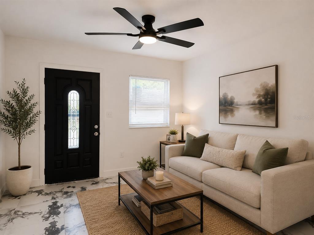 A living room features a black front door, a beige sofa, and a ceiling fan — 606 EL VEDADO AVENUE, ORLANDO, FL