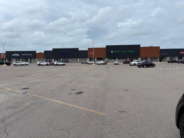 A large parking lot sits in front of a strip mall with several retail storefronts — 6812 14TH STREET W, BRADENTON, FL