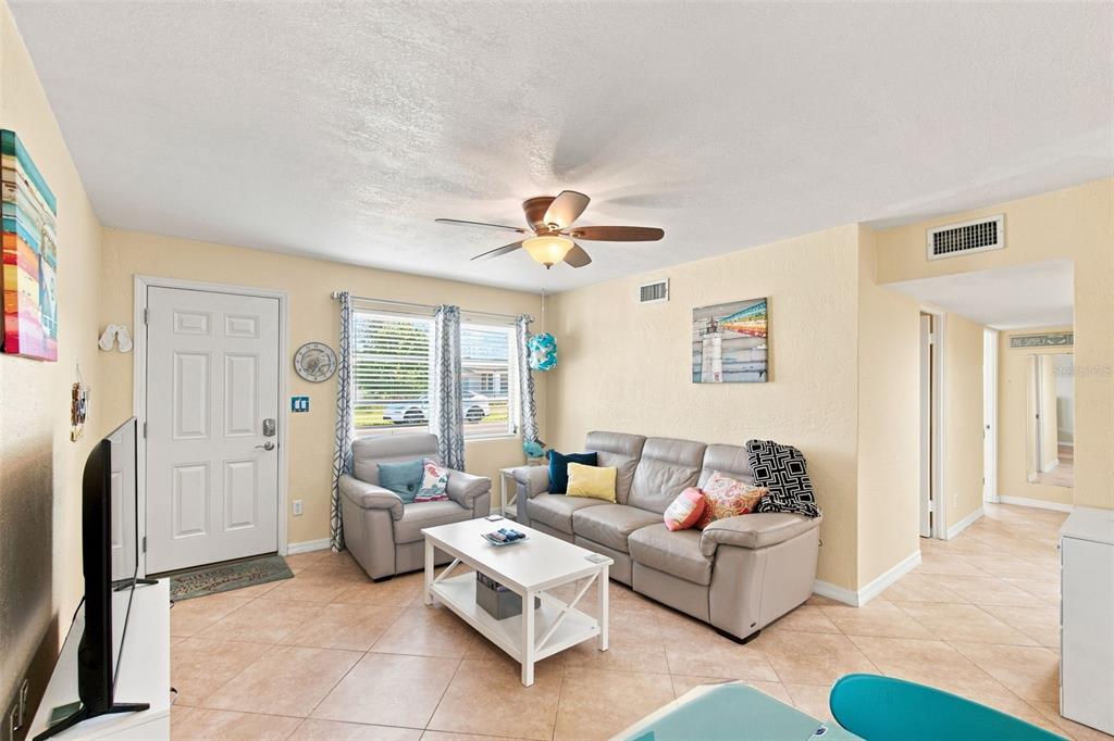 A living room with tile flooring, a beige sofa, an armchair, and a white coffee table — 414 FLUSHING AVENUE, DAYTONA BEACH, FL
