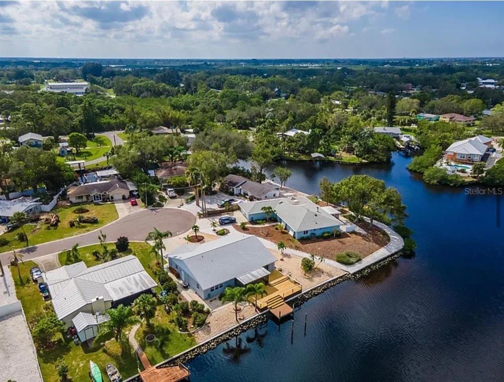 A single-story gray house with a white garage door and two palm trees in front — 805 LEISEY CIRCLE, RUSKIN, FL
