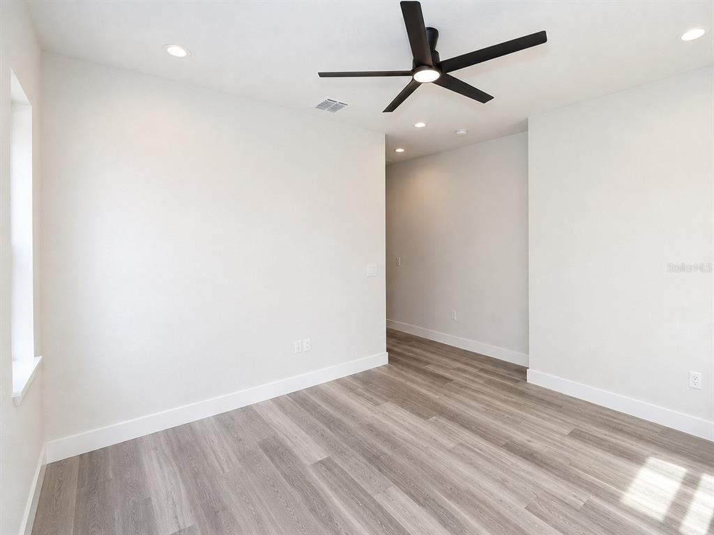 A room with light-colored walls, wood-look flooring, a ceiling fan, and recessed lighting — 3 WHELAN PLACE UNIT B, PALM COAST, FL