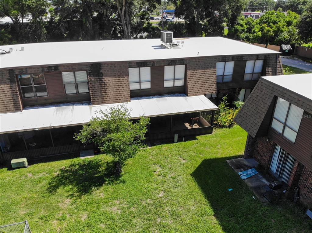 An aerial view shows a swimming pool situated between apartment buildings near a large lake — 1836 N CRYSTAL LAKE DRIVE UNIT 95, LAKELAND, FL