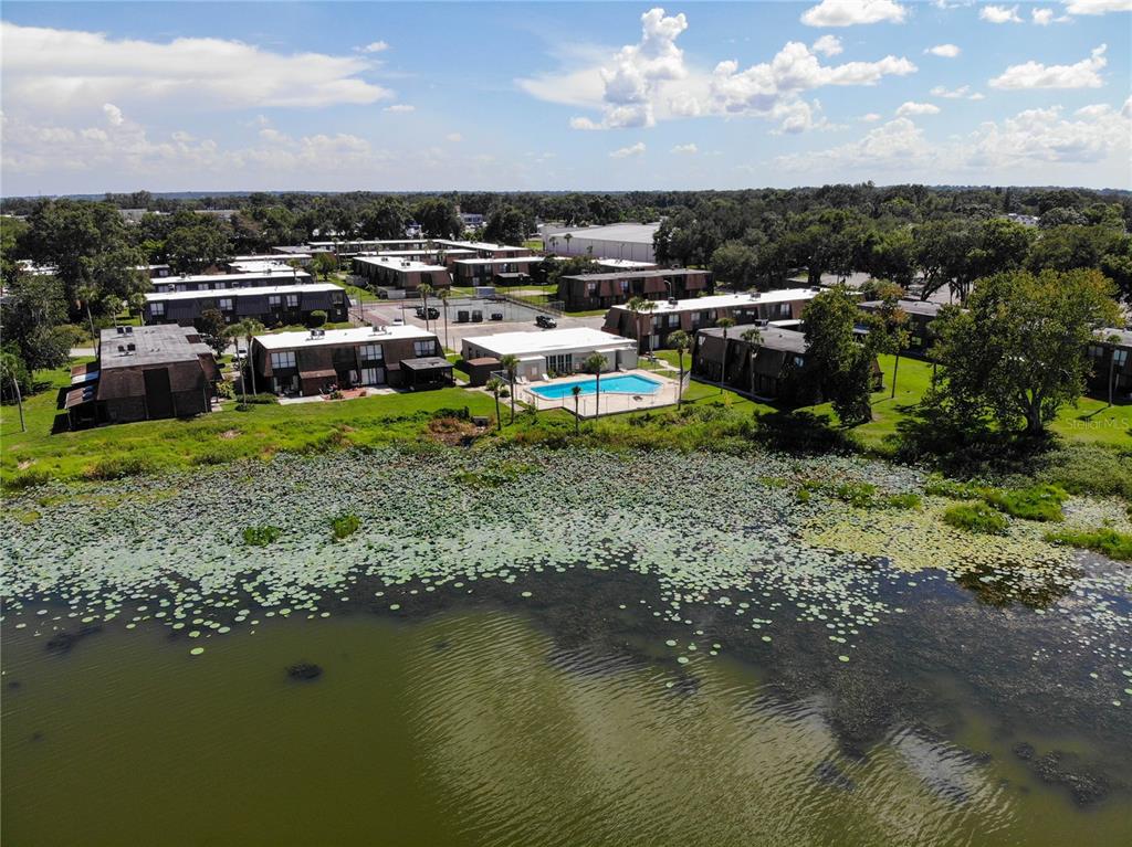 A two-story townhouse exterior features brown shingle siding, brick accents, and a concrete walkway — 1836 N CRYSTAL LAKE DRIVE UNIT 95, LAKELAND, FL