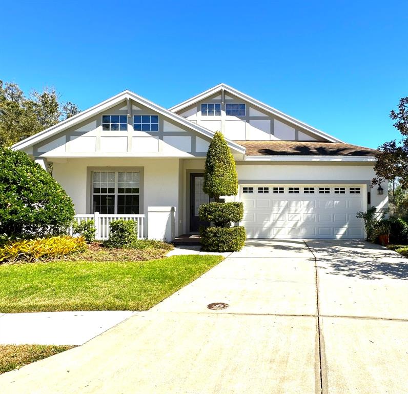A white house exterior features a covered porch, a brick walkway, and a large window — 8120 TURKEY HILL COURT, TAMPA, FL
