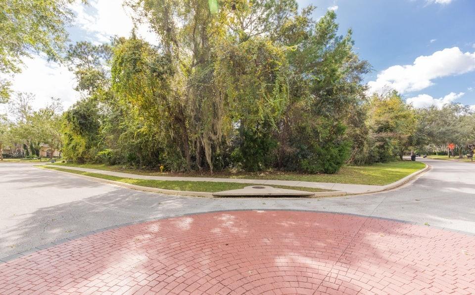 A corner lot with mature trees and a brick-paved intersection in a residential neighborhood — 15 INDIAN SPRINGS DRIVE, ORMOND BEACH, FL