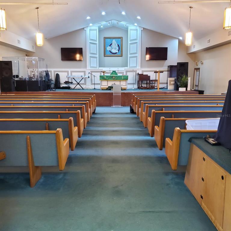 A church sanctuary features rows of pews facing a raised stage with an altar — 1250 PIEDMONT WEKIWA ROAD, APOPKA, FL