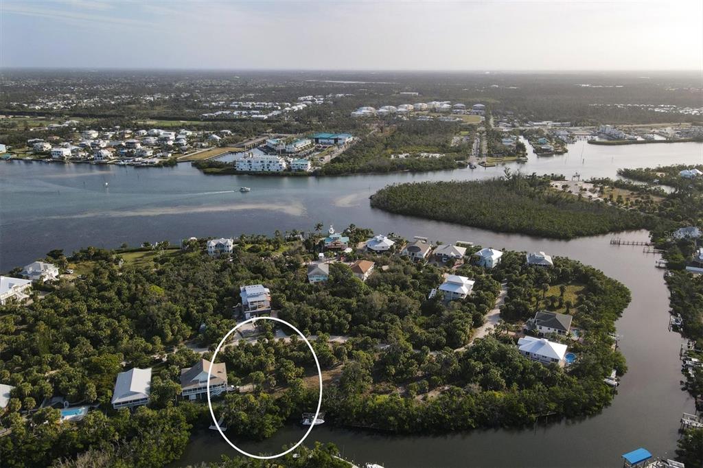 An aerial view shows a wooded waterfront lot with a house and a private dock — 21 BAYSHORE CIRCLE, PLACIDA, FL