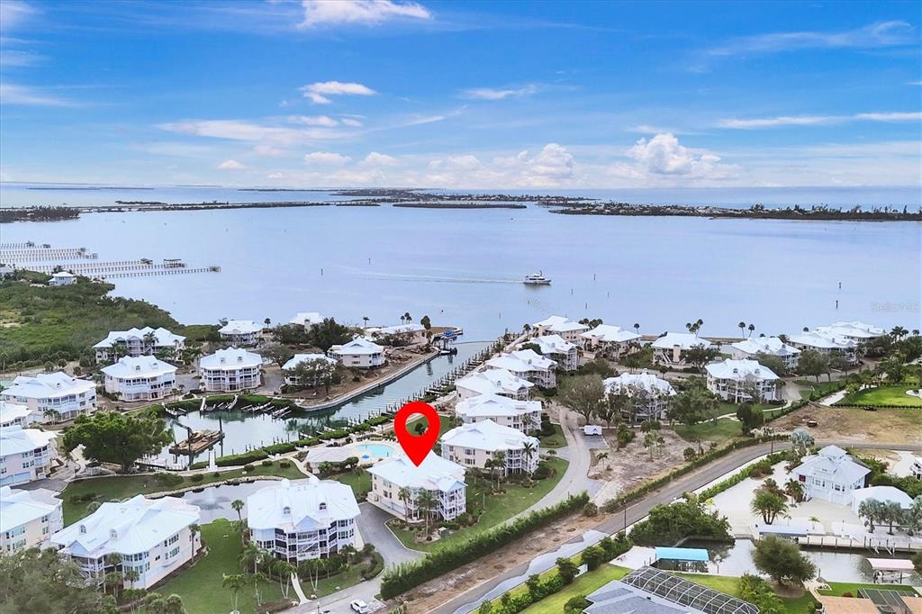 An aerial view shows a multi-story residential building marked with a red pin near water — 11000 PLACIDA ROAD UNIT 1601, PLACIDA, FL