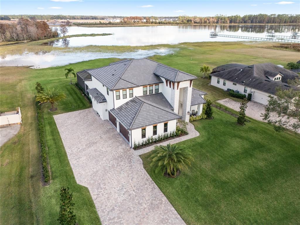 An aerial view shows a two-story house with a tile roof and a paved driveway — 3167 WHISPER WIND DRIVE, ST CLOUD, FL