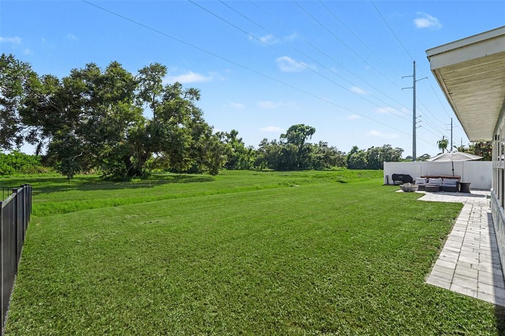 A backyard features a swimming pool with a tanning ledge, patio furniture, and a fire pit — 12080 66TH AVENUE, SEMINOLE, FL