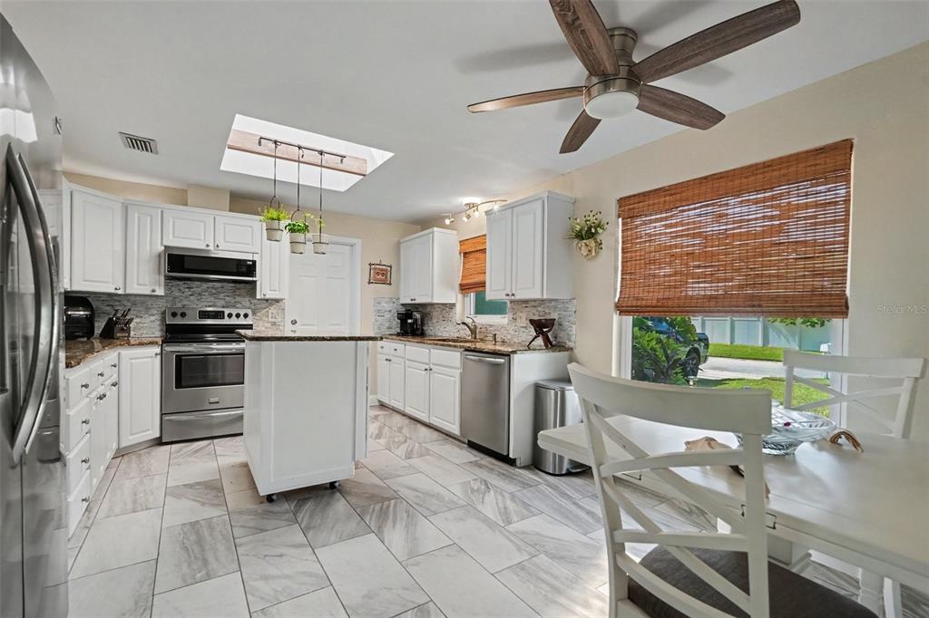 A blue single-story house features a two-car garage, a concrete driveway, and a front lawn — 12080 66TH AVENUE, SEMINOLE, FL