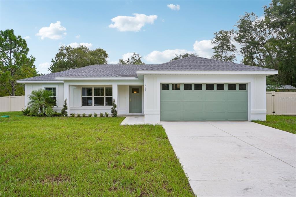 A single-story house with a white exterior, green garage door, and a concrete driveway — 509 W WASON STREET, CITRUS SPRINGS, FL