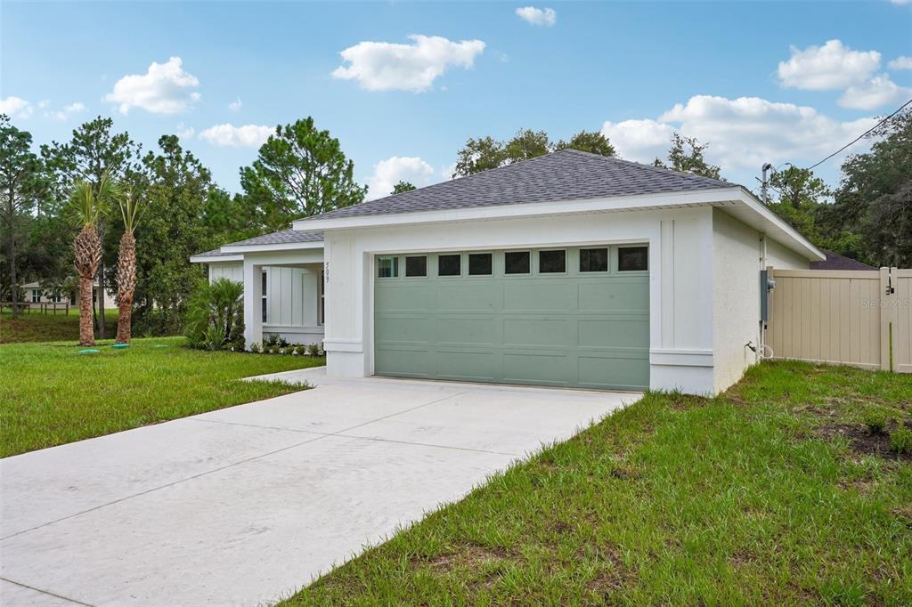 A single-story house with a green garage door, white stucco exterior, and a concrete driveway — 509 W WASON STREET, CITRUS SPRINGS, FL