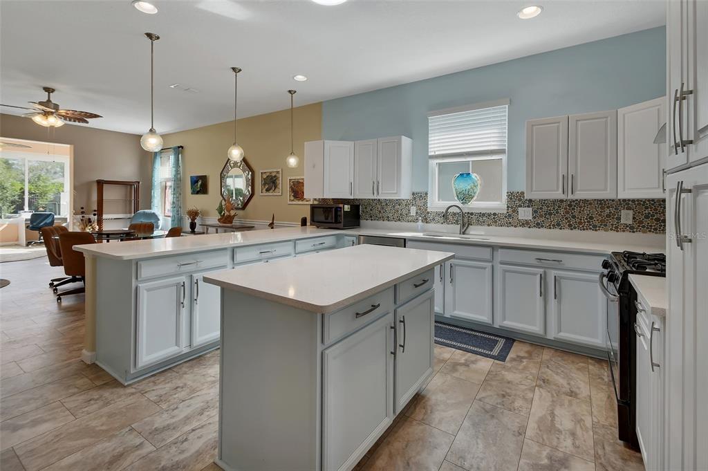 A living room features a large television on a fireplace console, tile flooring, and stairs — 337 ORCHARD HILL STREET, DELAND, FL