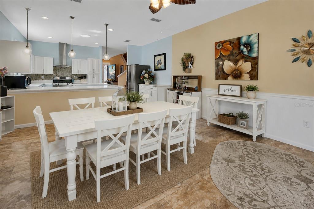 A living room features tile flooring, a circular rug, a ceiling fan, and coastal decor — 337 ORCHARD HILL STREET, DELAND, FL