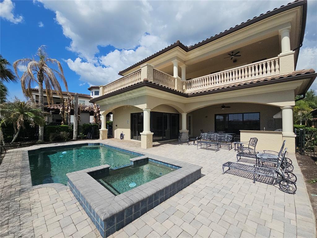 A two-story house features a backyard patio with a swimming pool and attached spa — 420 MUIRFIELD LOOP, REUNION, FL