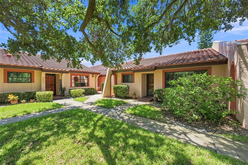 A low-rise residential building with a tiled roof, stucco exterior, and landscaped front yard — 9683 86TH AVENUE, SEMINOLE, FL