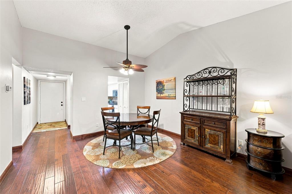 A dining area features a round table, dark wood floors, and a decorative hutch — 9683 86TH AVENUE, SEMINOLE, FL