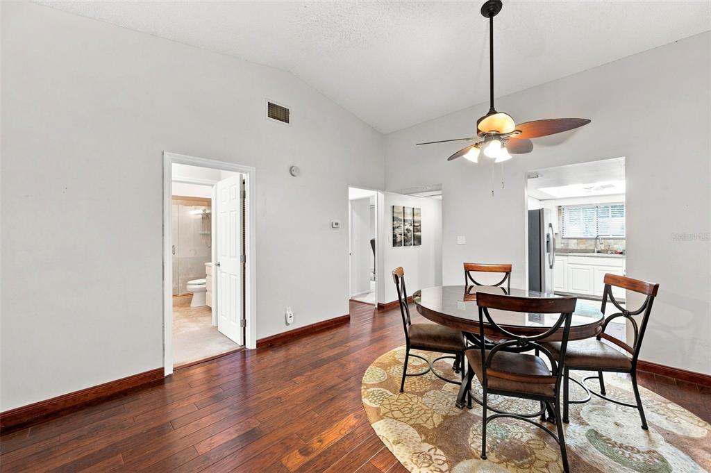 A dining area with a round table, dark wood floors, and a ceiling fan — 9683 86TH AVENUE, SEMINOLE, FL