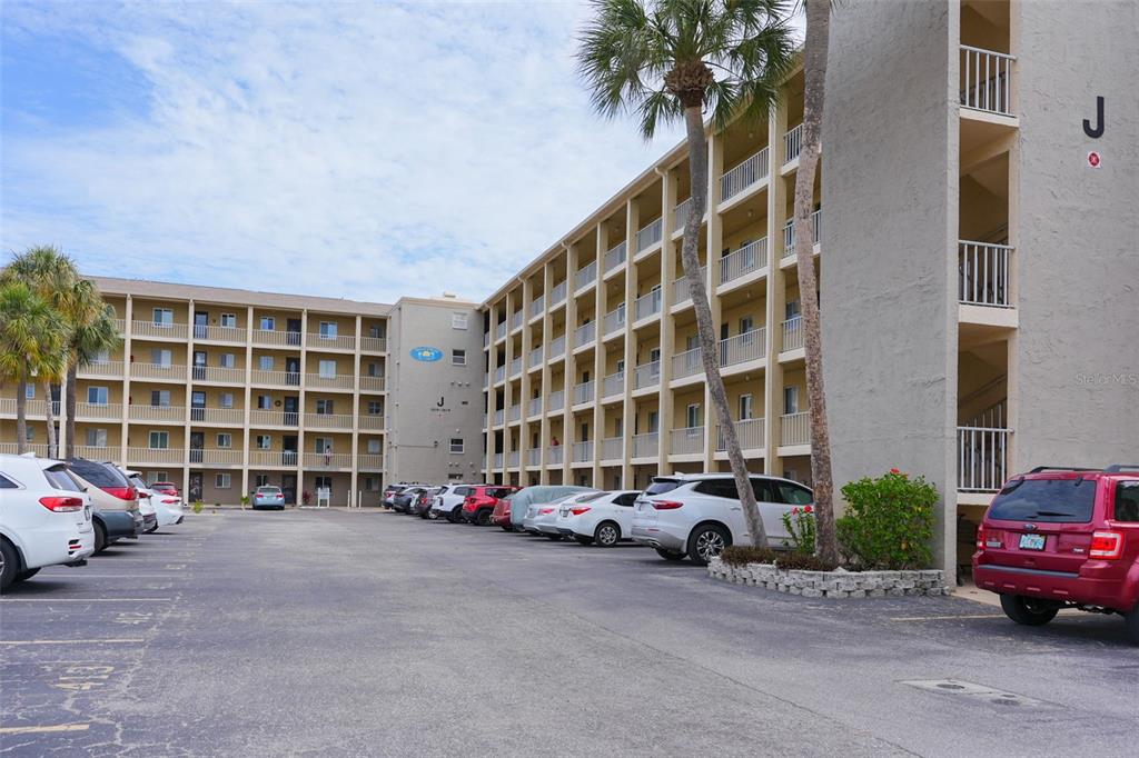 A multi-story apartment building with exterior walkways and a parking lot in the foreground — 3607 LAKE BAYSHORE DRIVE UNIT J-312, BRADENTON, FL