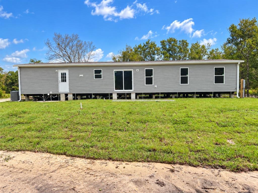 A kitchen with white cabinets, stainless steel appliances, and an island opens to a deck — 19732 NW 280TH STREET, OKEECHOBEE, FL