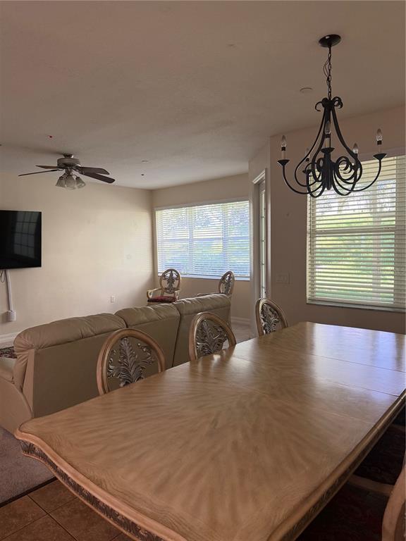 A dining area with a wooden table and chandelier sits adjacent to a living room — 7460 TERRACE RIVER DRIVE, TEMPLE TERRACE, FL